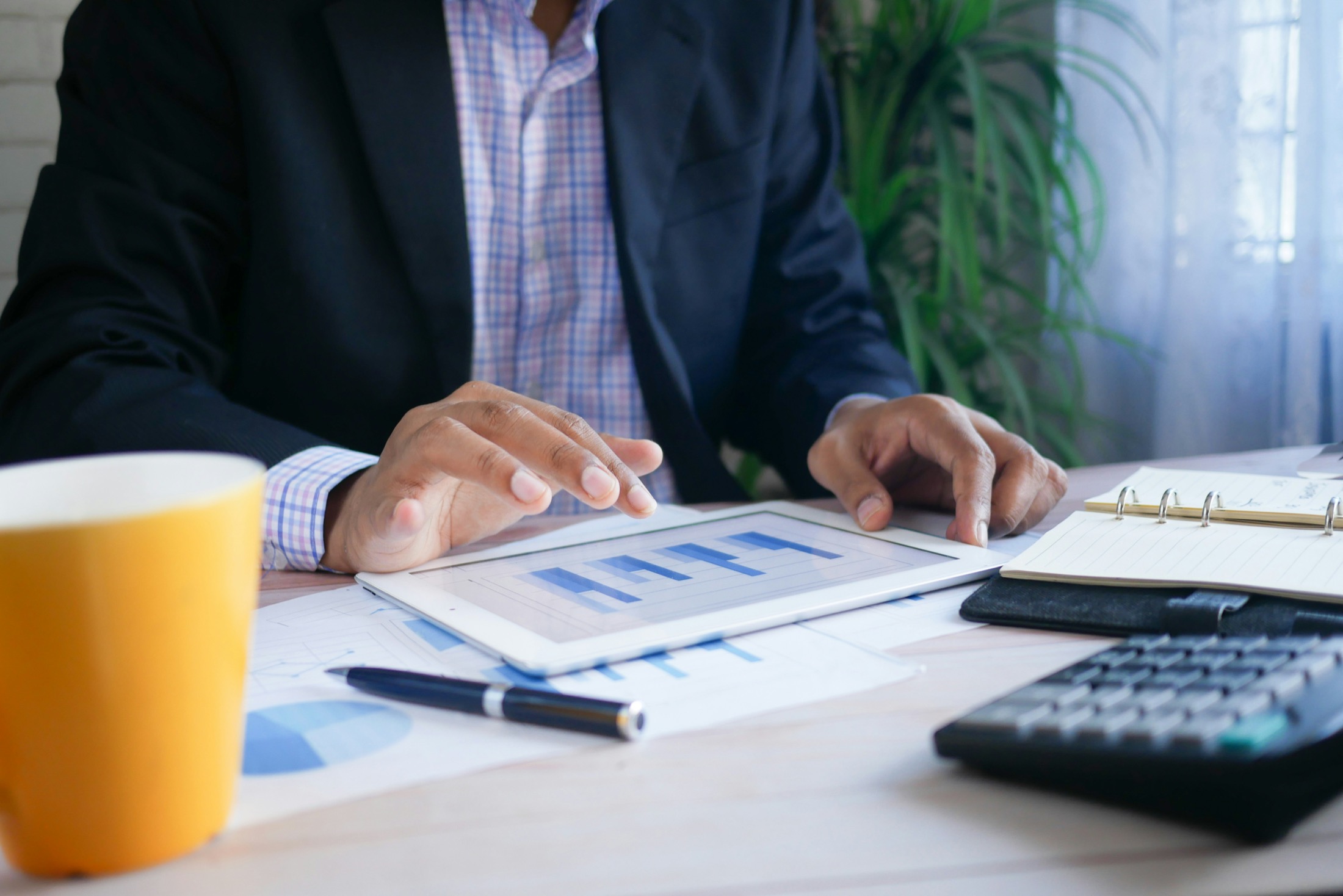 Klavyenin yanında finansal raporları inceleyen kişi